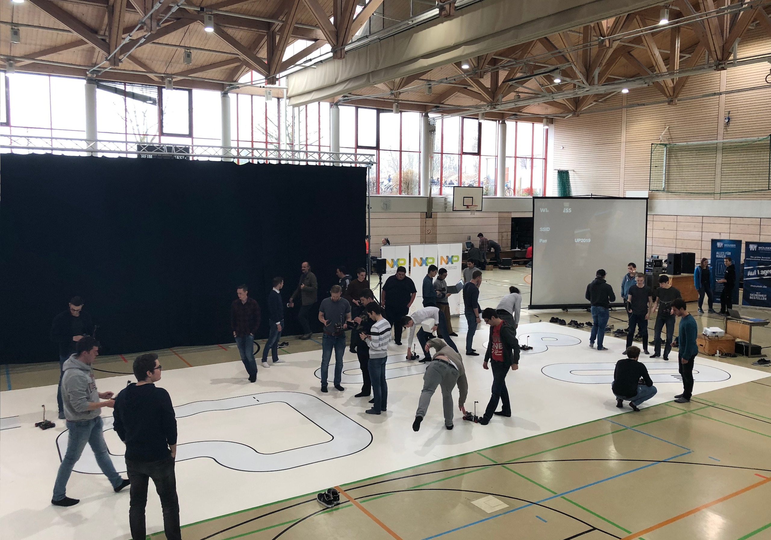 Student teams standing on the NXP Cup tracks